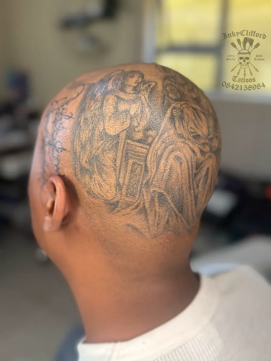 Back of a person's shaved head with a large detailed tattoo depicting religious or angelic figures
